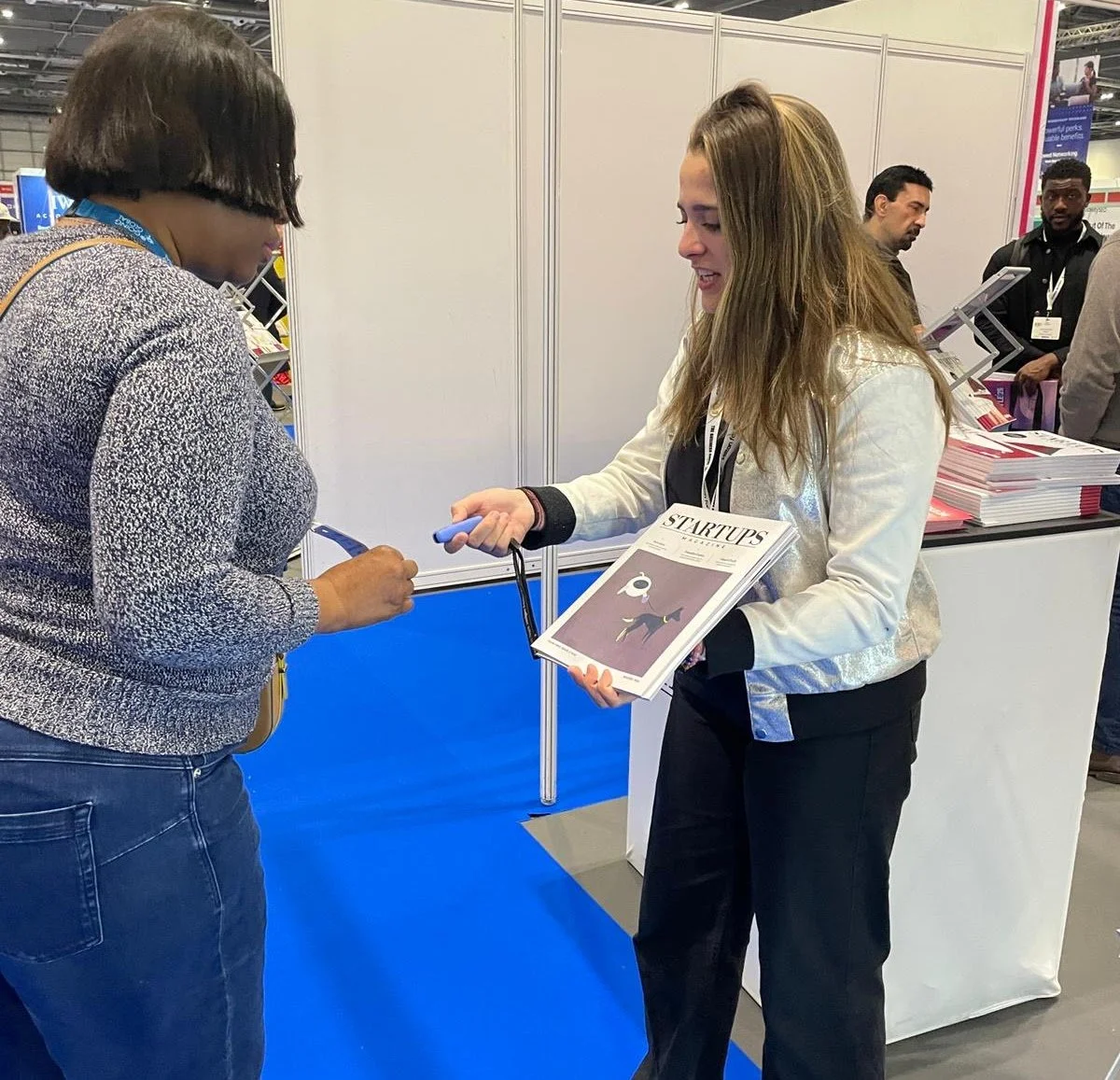 Supporting attendees at an exhibition stand, assisting with information and materials during a live event.