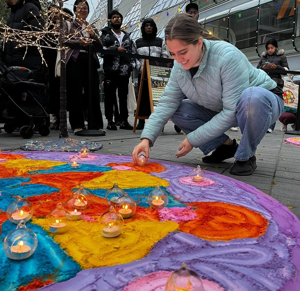 Participating in a public community art installation as part of a live event, supporting audience engagement and experience.