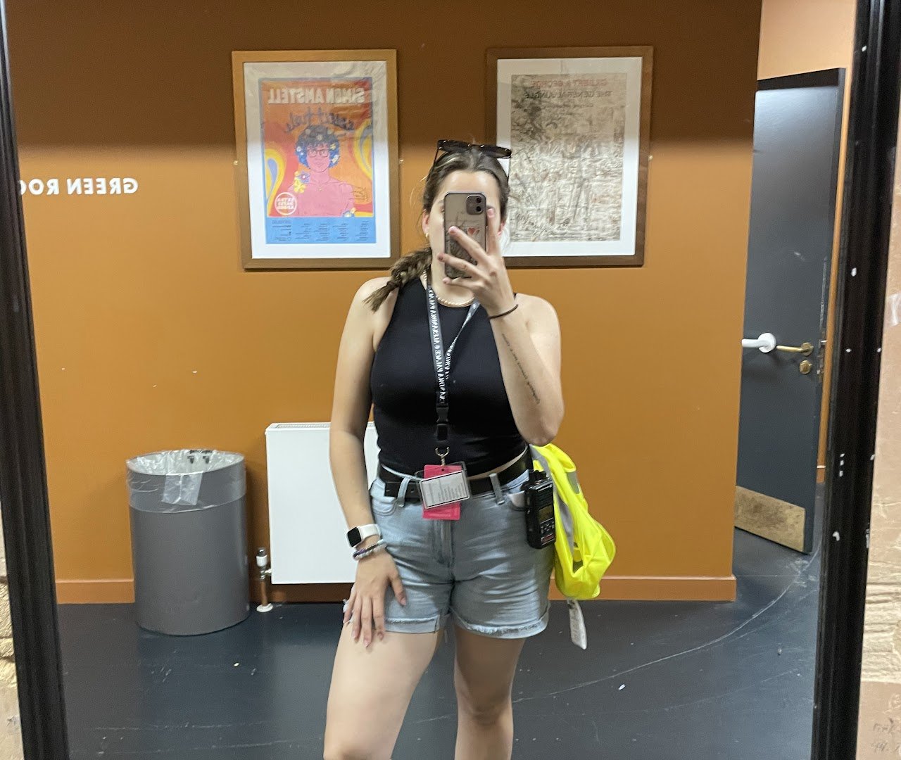 Event staff member taking a quick selfie on site while working, wearing high-visibility and crew gear.