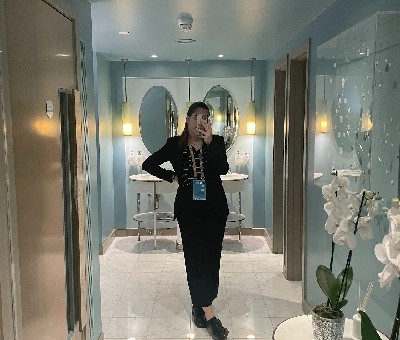 An event professional preparing on site in formal attire before a live event, wearing an accreditation badge.