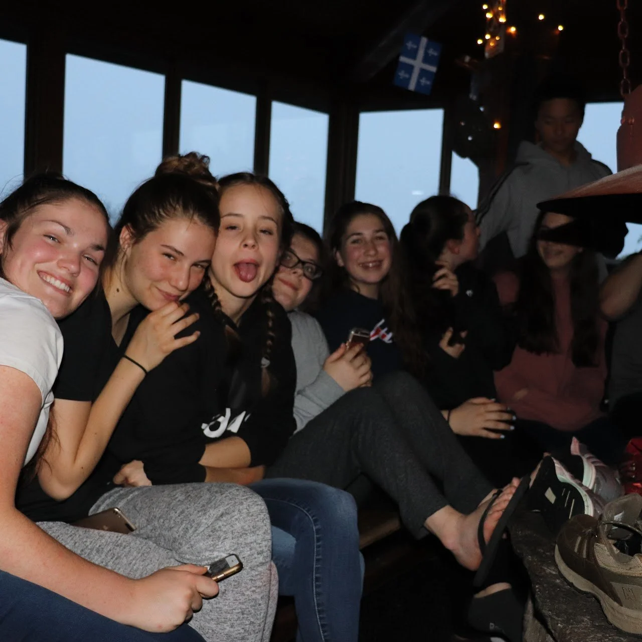 Friends sitting closely together and smiling during a shared moment on my first event trip, highlighting connection and teamwork.