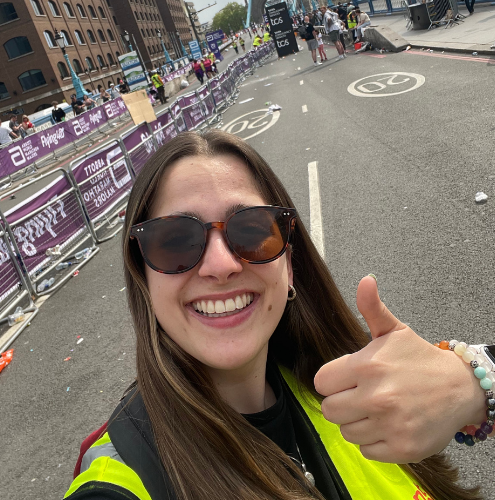 Smiling on site during a live outdoor event, bringing positive energy and a calm presence to the event team.