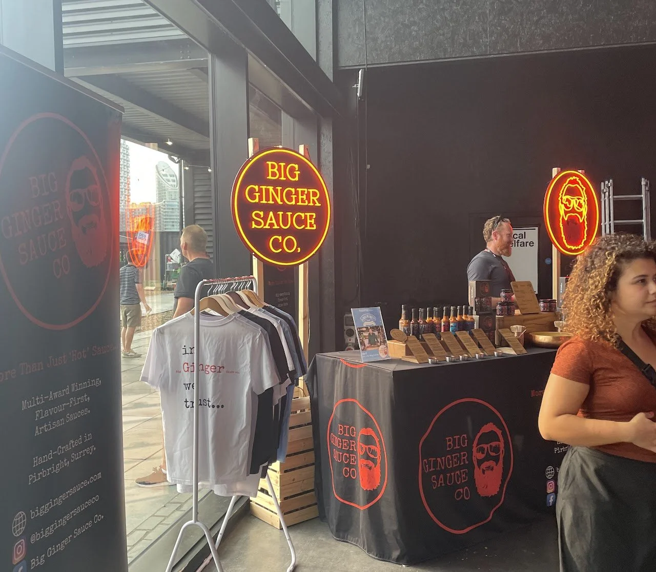 Branded vendor stall set up inside an event venue, showcasing merchandise and products during an event.