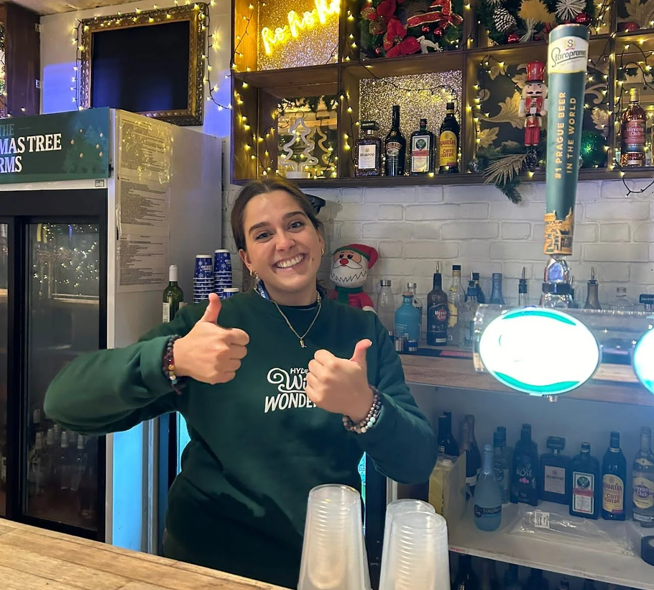 Working behind the bar at an indoor venue, providing drinks service during a live event.