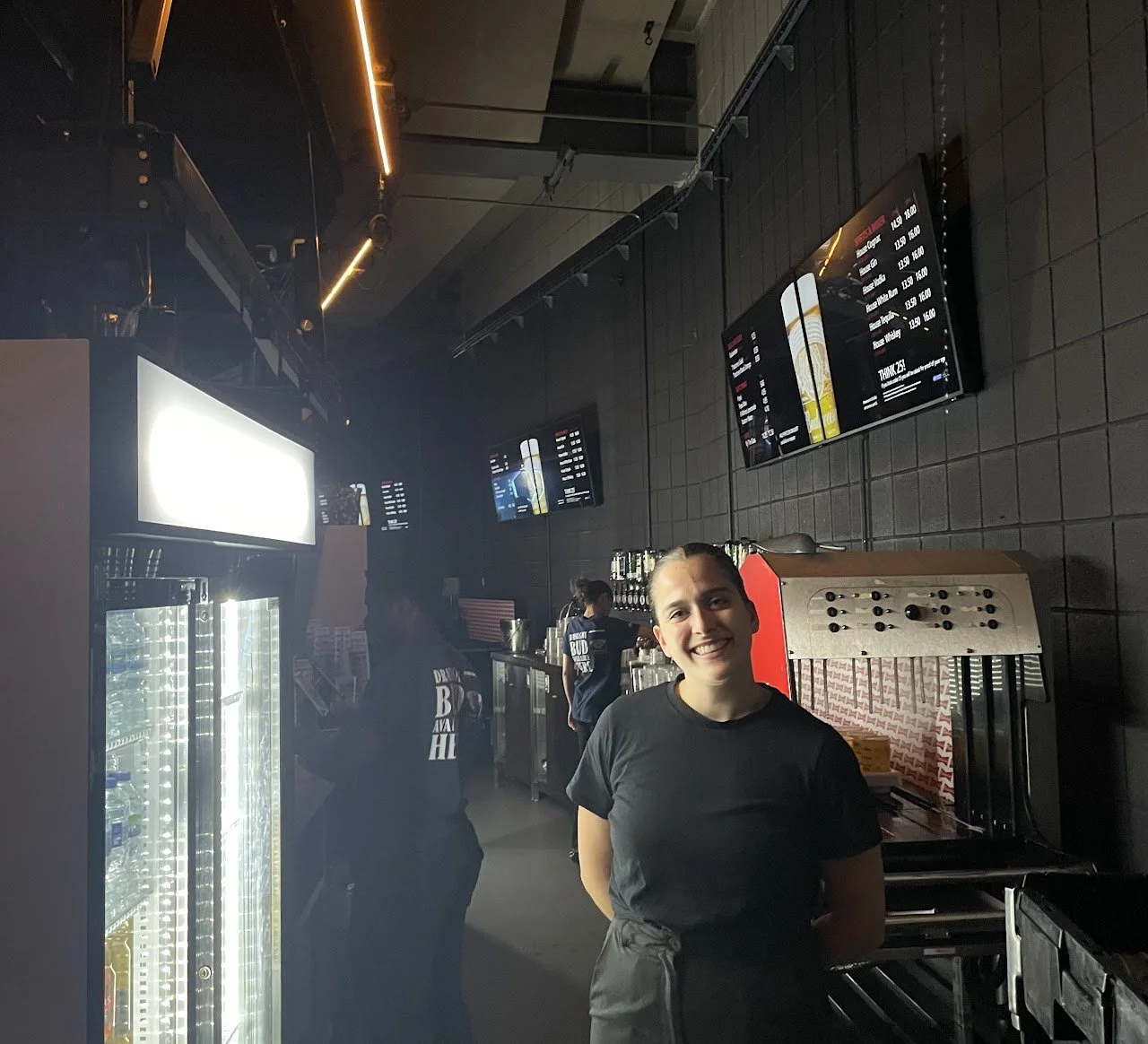 Bar staff member on site at a large indoor venue, supporting bar operations during an event.