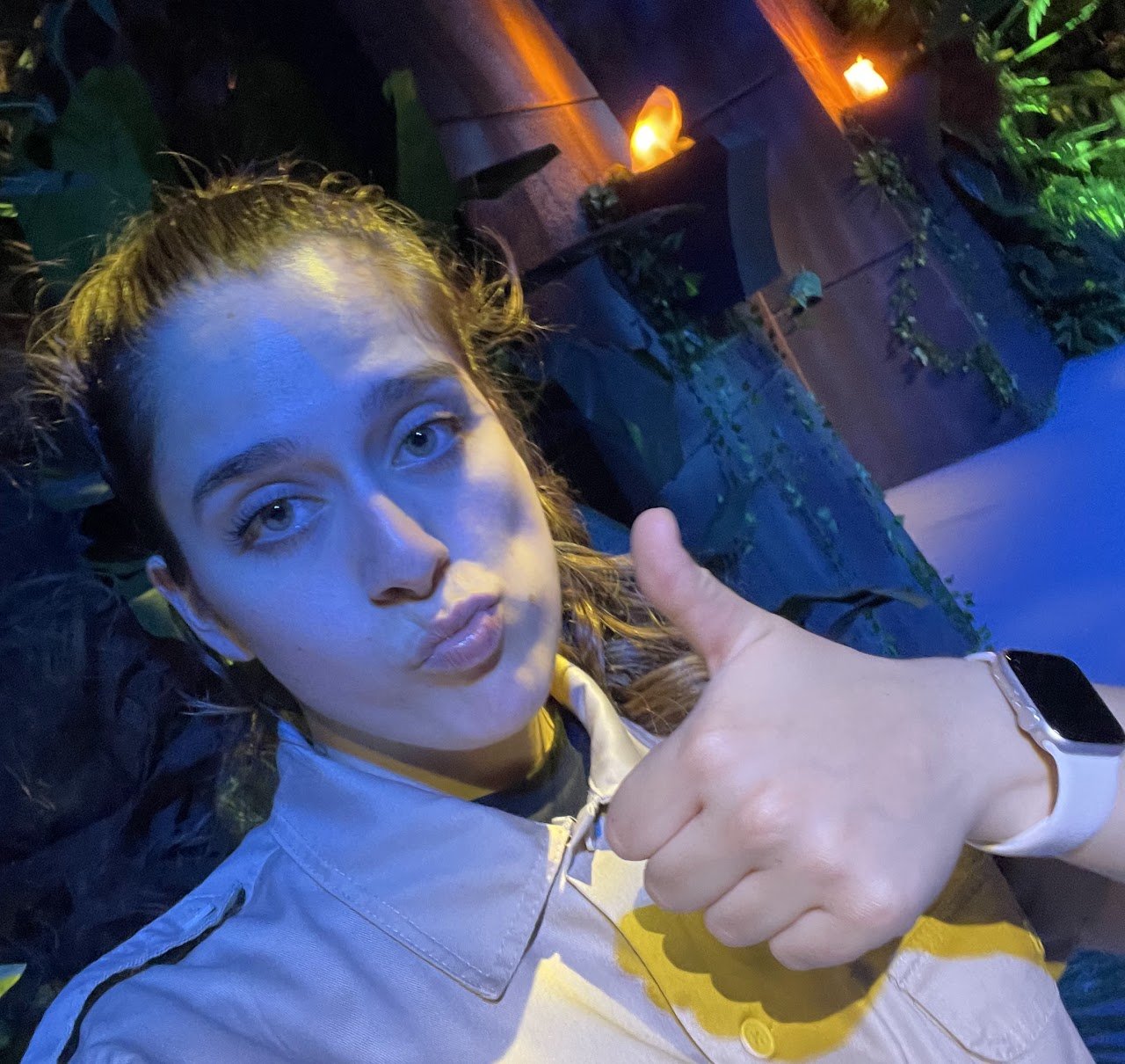 Event staff member giving a thumbs up while working inside an immersive exhibition environment.