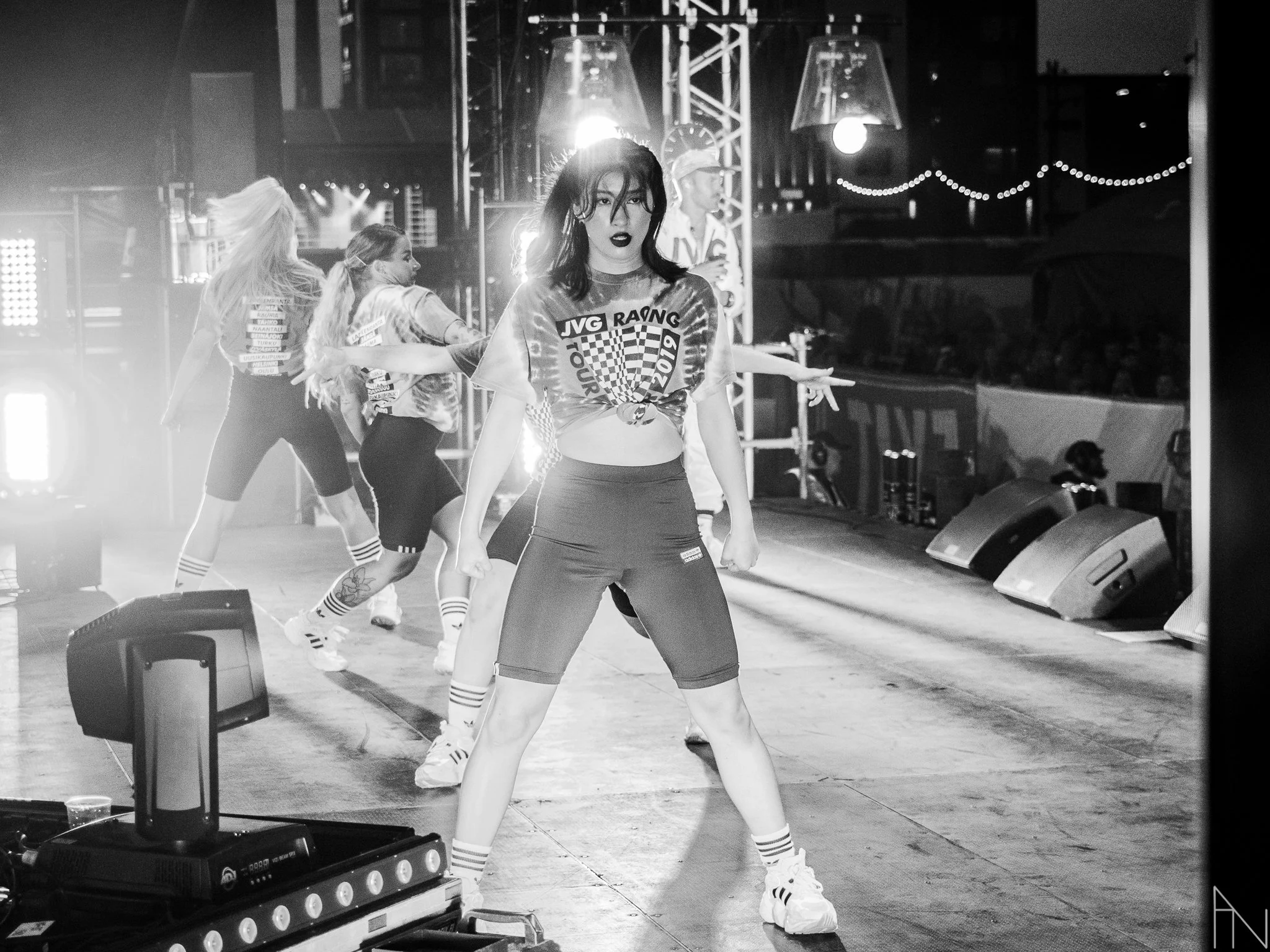 Kuvassa nuoria tanssimassa esityksessä, yksi eturintamassa, mustavalkoinen kuva, taustalla valo- ja äänitekniikka. Linh Lin, JVG, Suomipop Festivaali Jyväskylä.