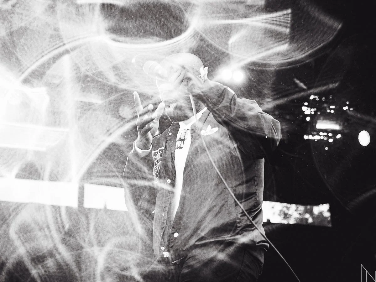 Mies esiintymässä tai tekemässä musiikkia, ympärillä valoefektejä, mustavalkokuva.