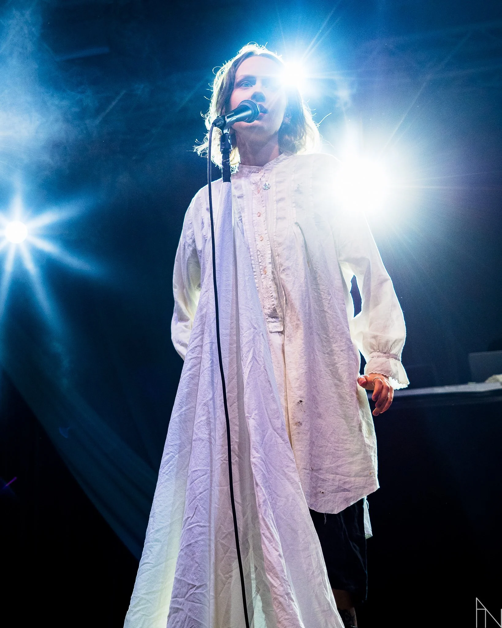 Pehmoaino mikrofonin kanssa valojen loistaessa taustalla.