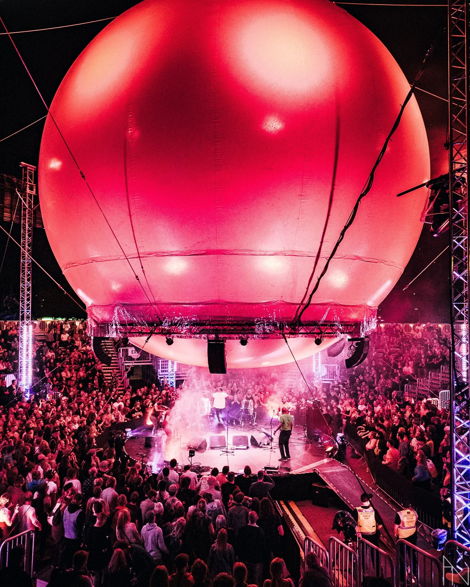 Suuri konserttitapahtuma näyttävässä ympäristössä, jossa suuri ilmatäytteinen pallo viedään ylös yleisön keskellä. Flow Festival Balloon Stage.