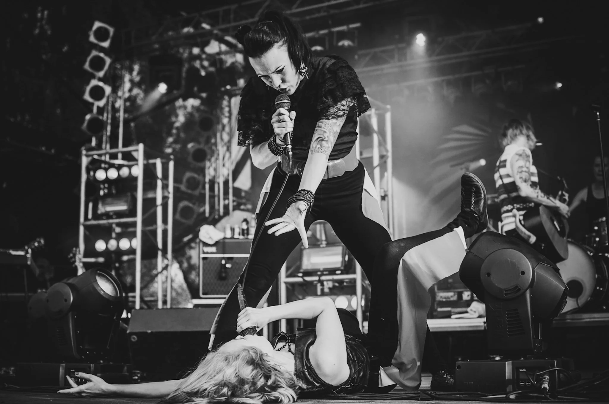 PMMP Jurassic Rock, nainen seisoo toisen naisen päällä lavalla, esittäen voimakasta ja intensiivistä esitystä.