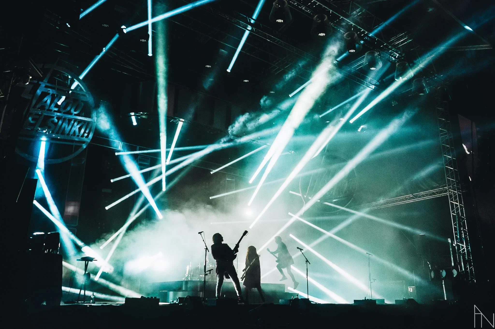 Live musiikkitapahtuma, lavalla esiintyy ja soittaa kolme muusikkoa ja käytetään valoefektejä.