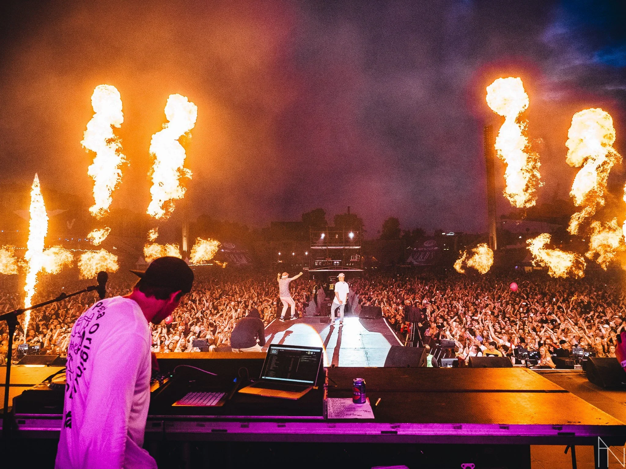 Konsertti tai festivaali, jossa esiintyjät lavalla, yleisö tanssimassa ja ilotulituksia tai pyroja taivaalla yöllä. JVG Blockfest.