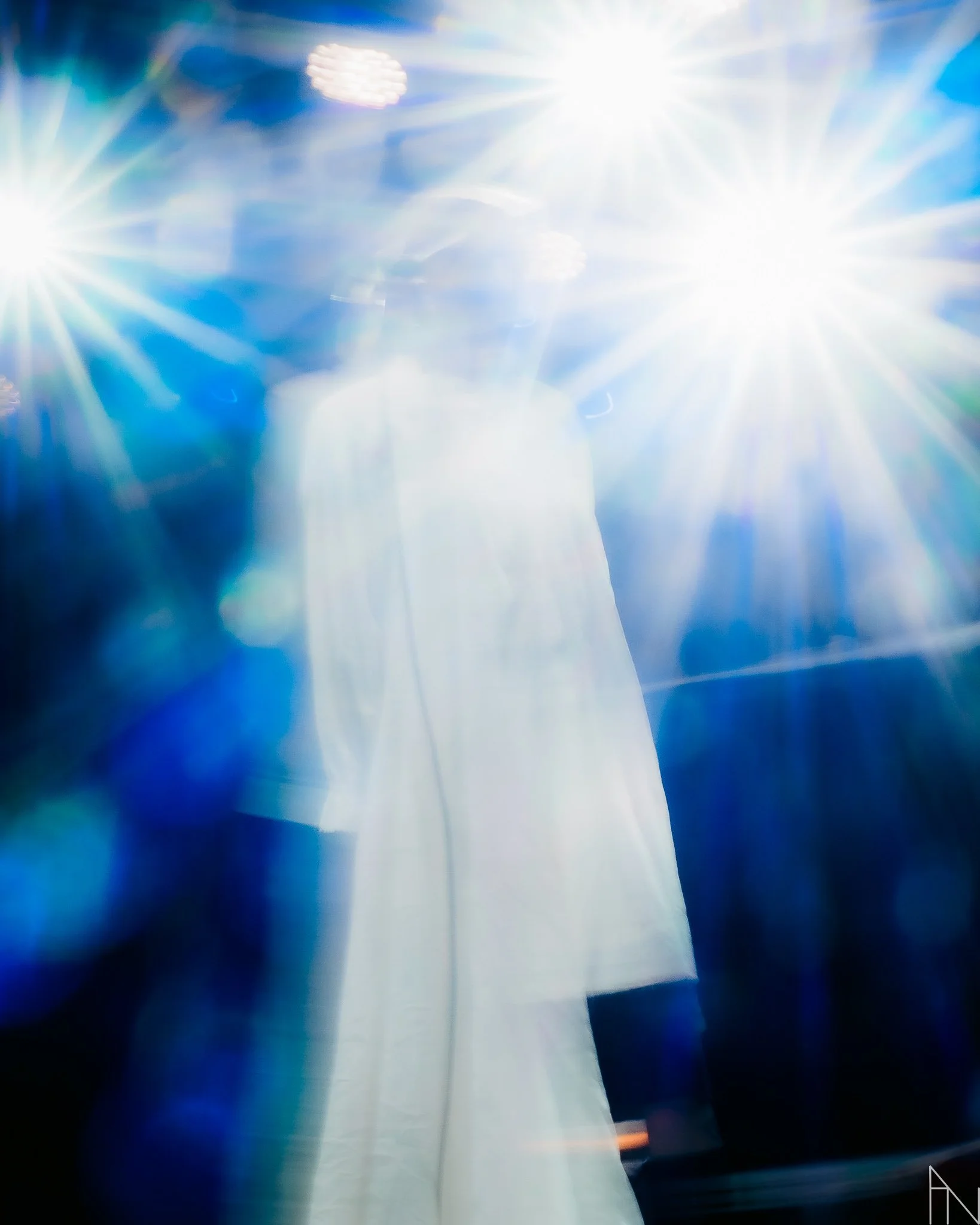 Henkilö nuoresta naisesta, joka pitää vaaleaa mekkoa, valkoinen vaate ja valoisa ympäristö.