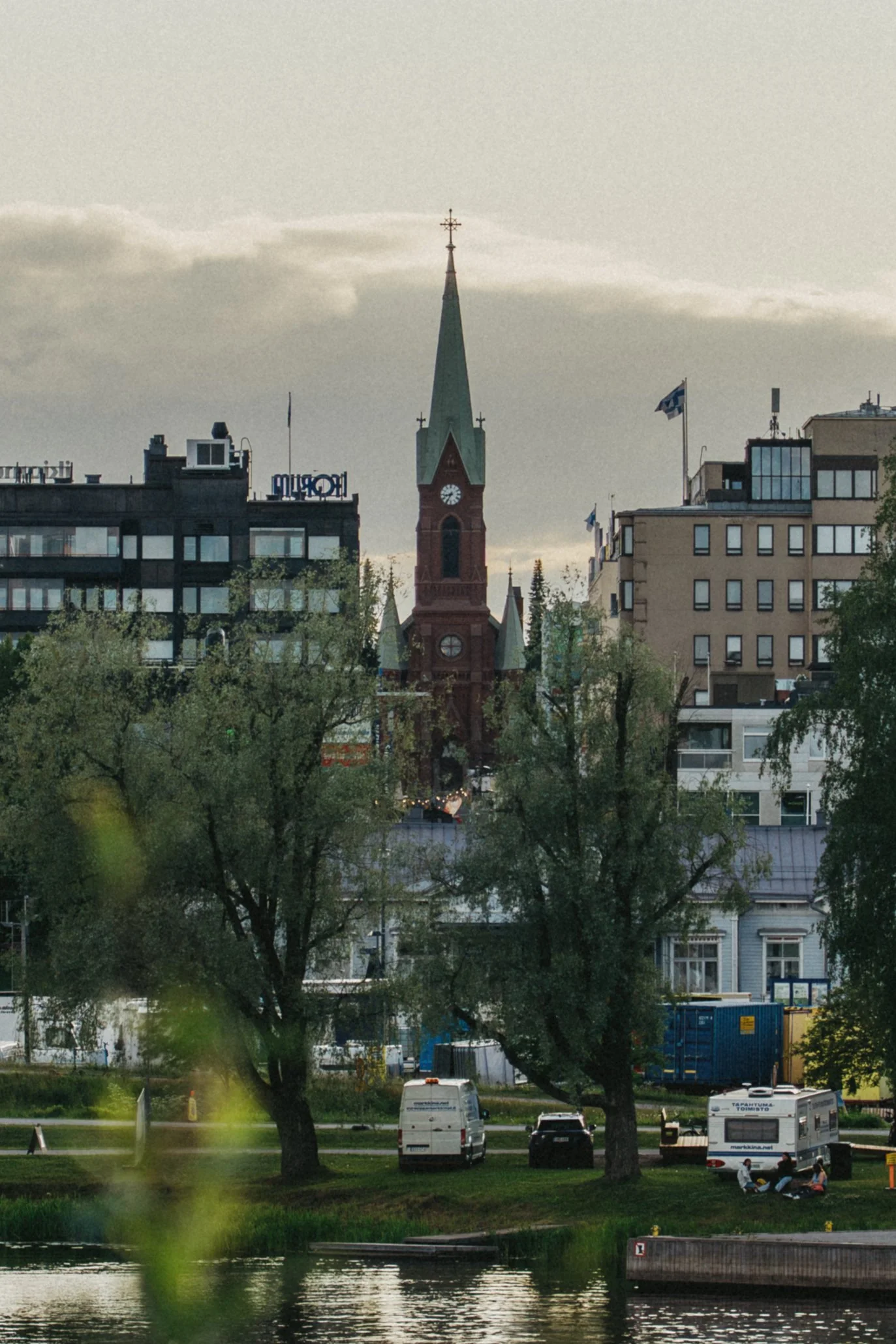 Kaupunkinäkymä, jossa Mikkelin tuomiokirkon torni ja kerrostaloja, puita ja autoja.