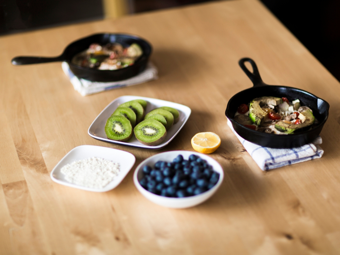 A brown table with bowls of fruit and vegetables.