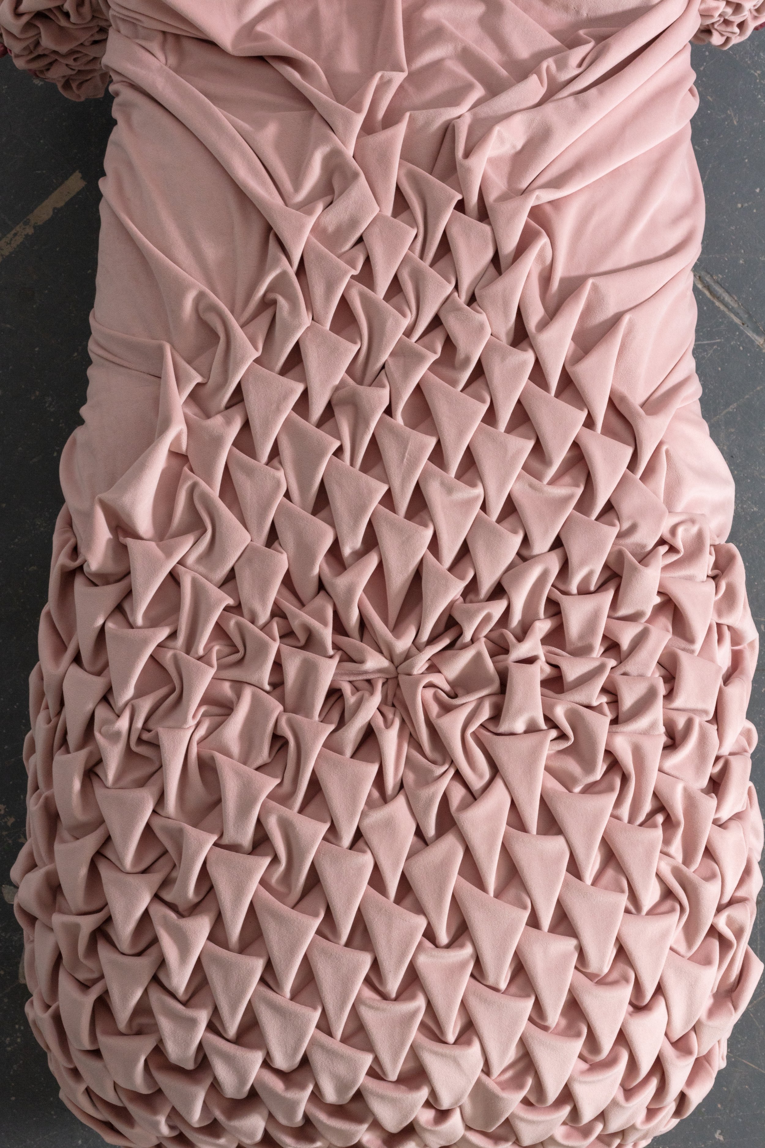 Pink fabric arranged in a repeating diamond pattern.