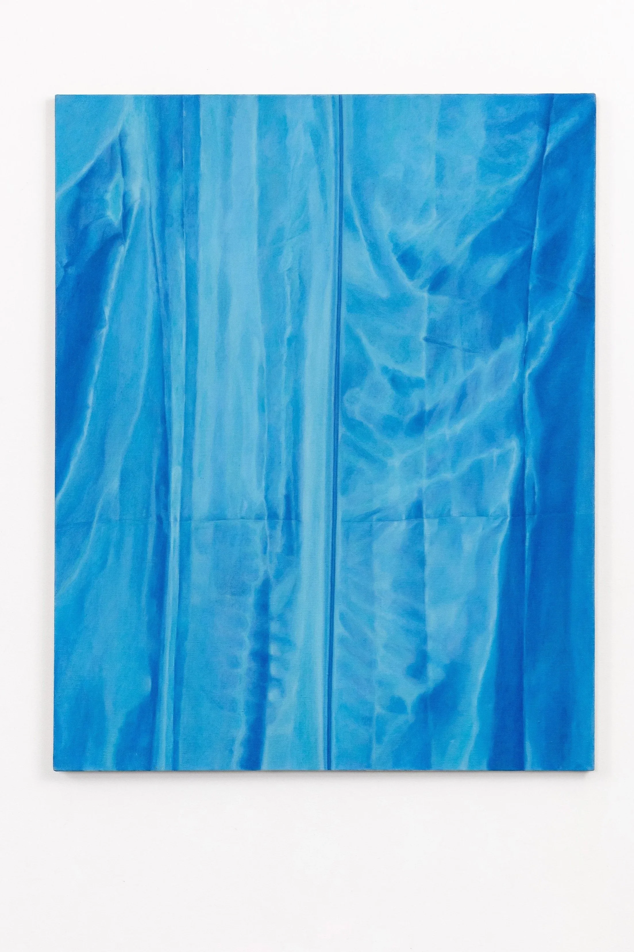 A blue crinkled paper or fabric sheet with a zipper in the middle, placed on a plain white background.