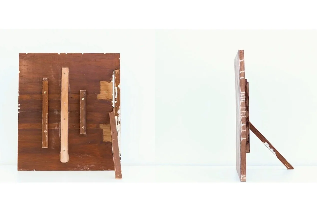 View of two wooden panels, one lying flat with cross braces and the other standing on its side, both against a plain white background.