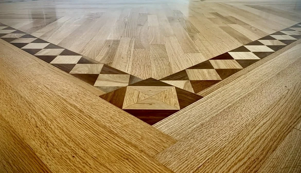 Custom geometric hardwood floor inlay and border handcrafted by Goodman Custom Flooring in Summersville, West Virginia.