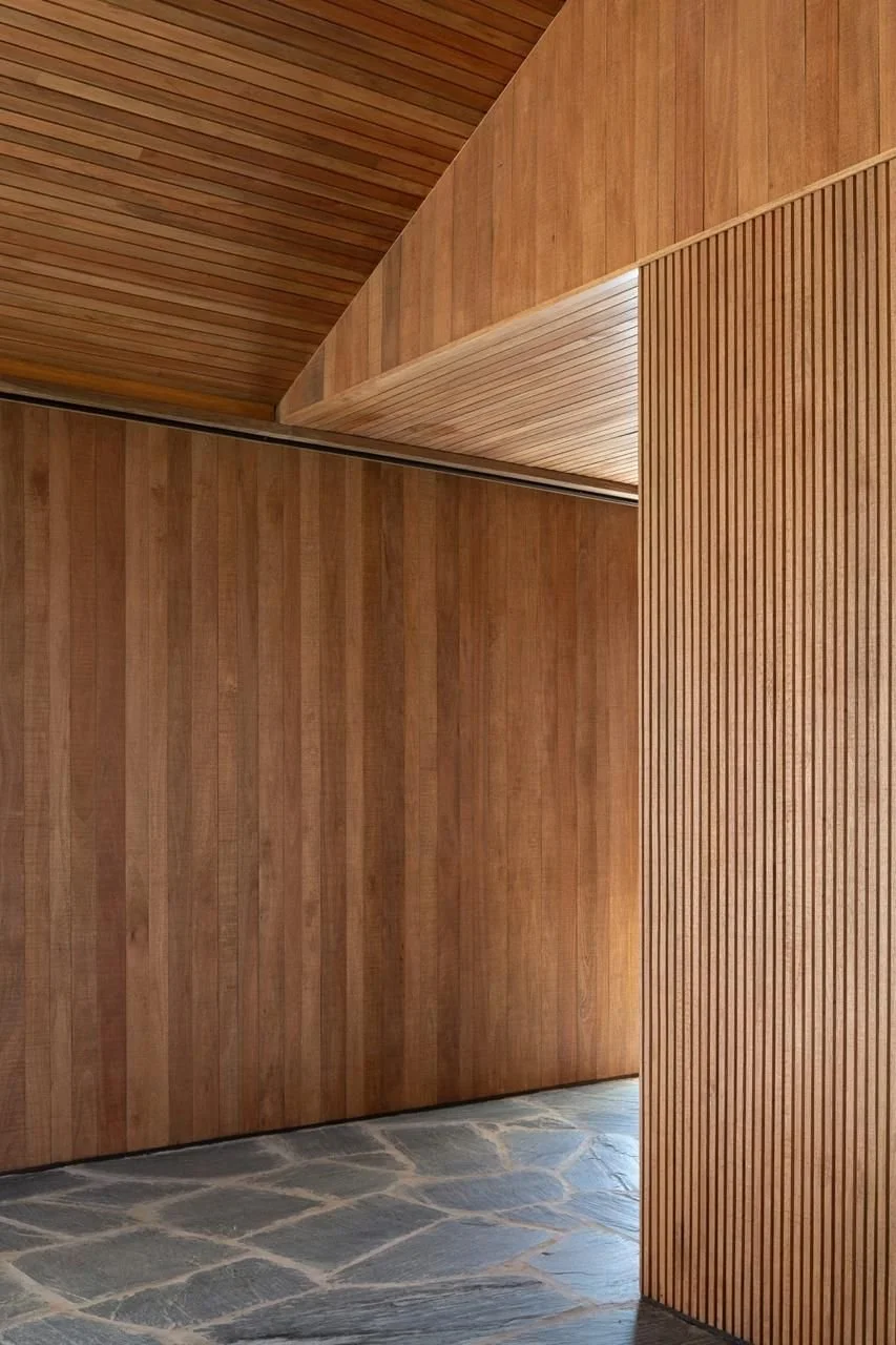 Interior view of a space with wooden walls and ceiling, featuring vertical and horizontal wooden paneling, and a palladiana floor.