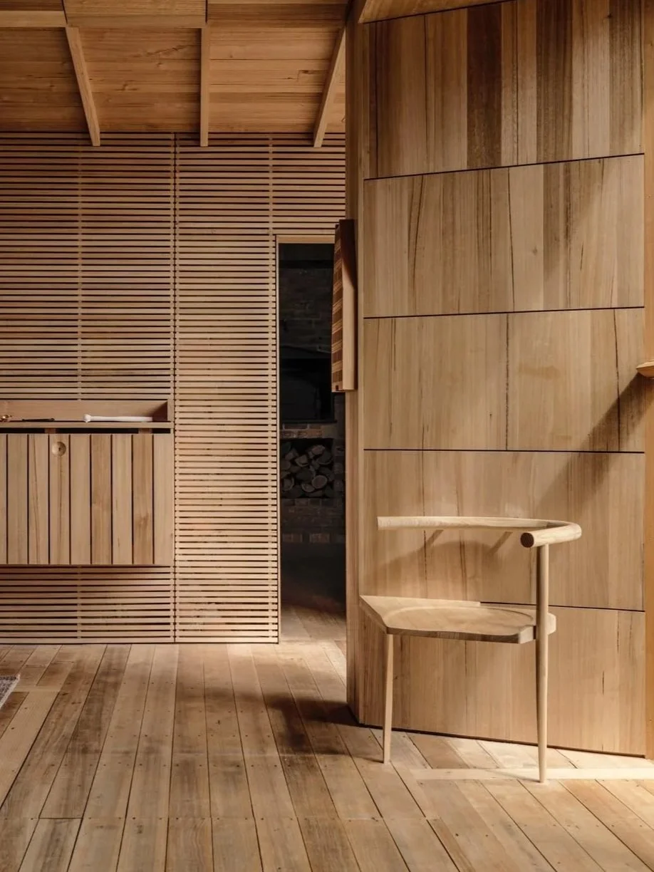 Interior view of a room with wooden wall paneling, a wooden chair, and warm lighting. Wood drenching.
