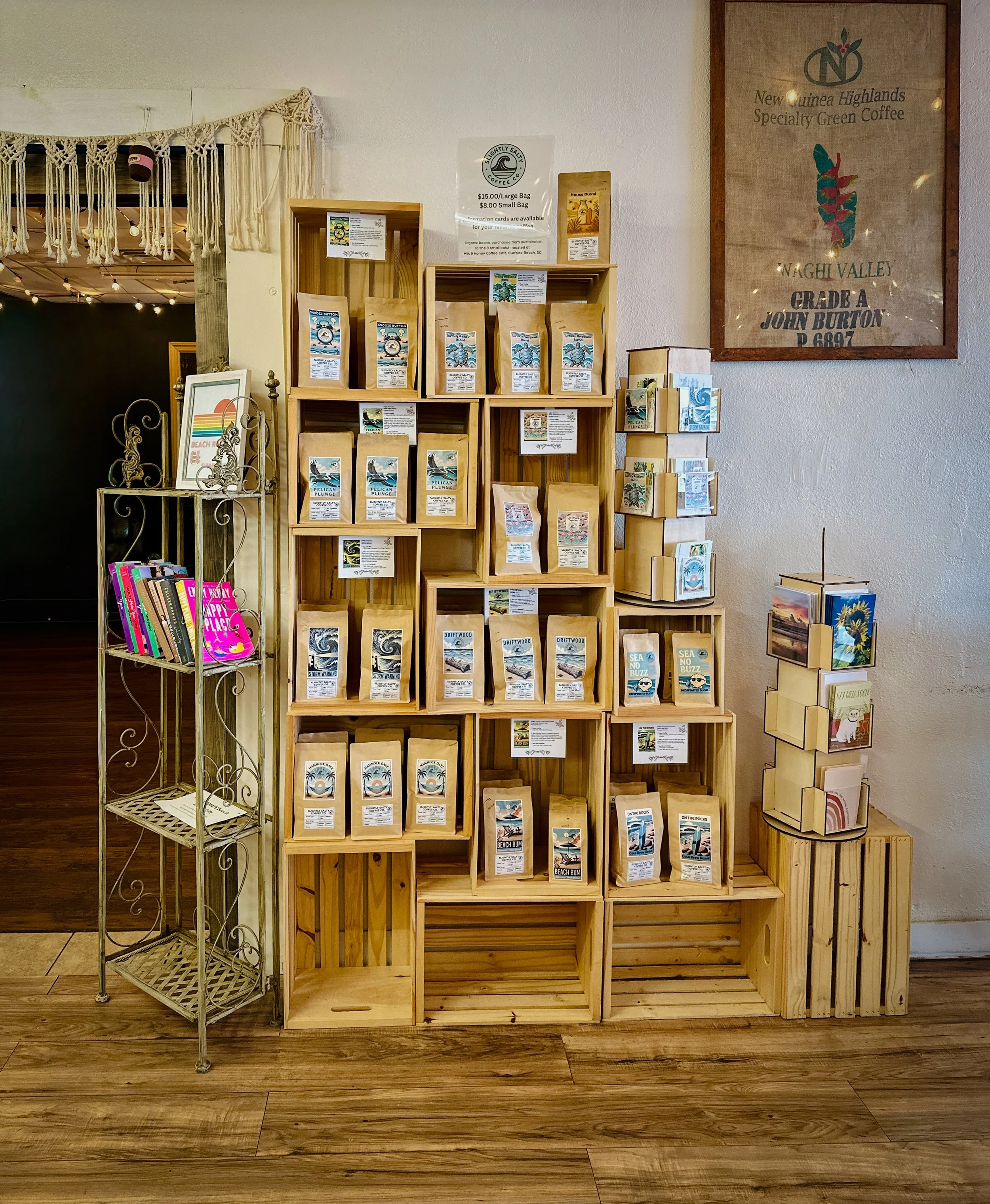 Slightly Salty Coffee Co. coffee bag display with ocean themed gift cards and assorted books on a shelf.