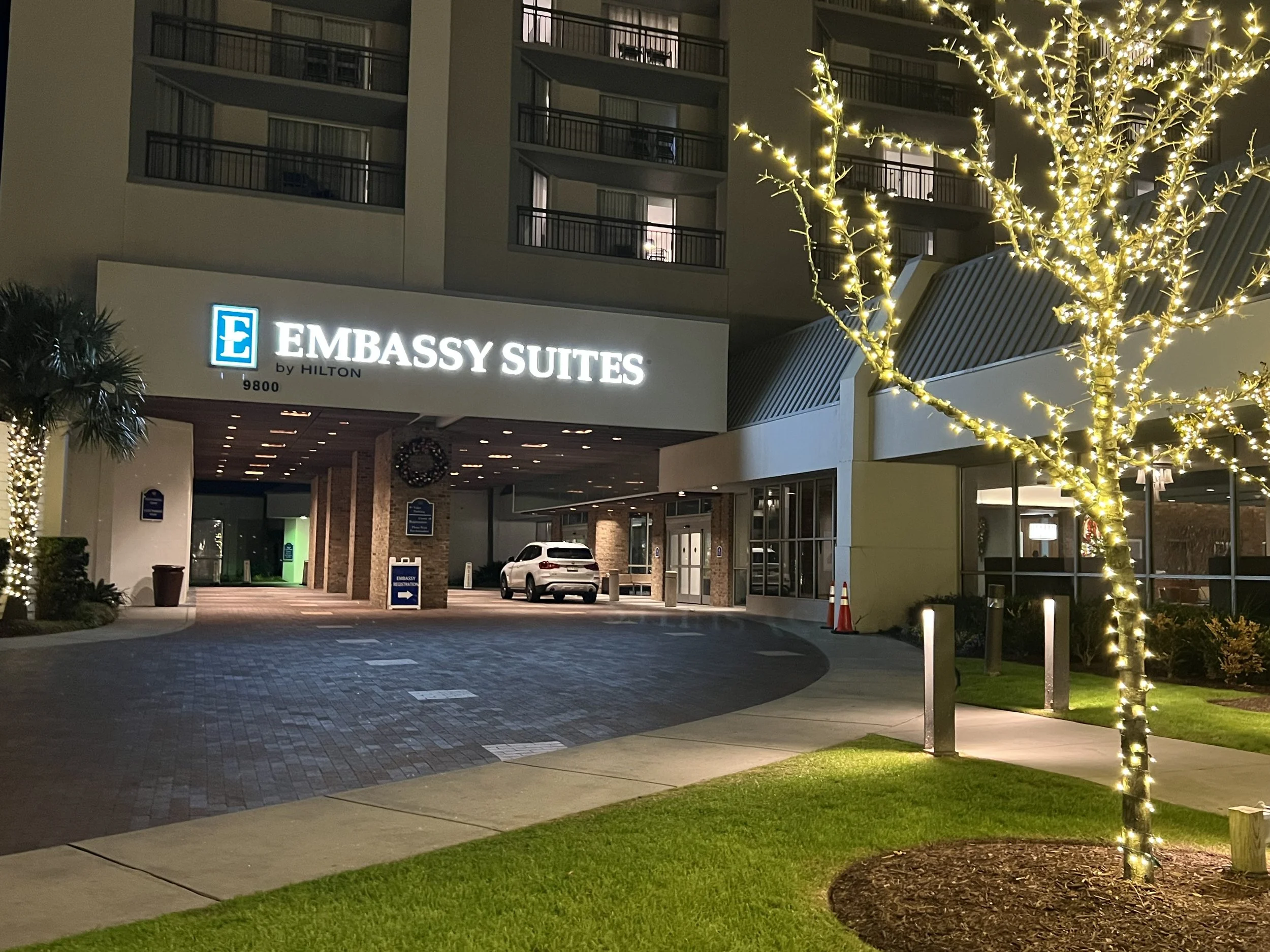 Embassy Suites entrance with pretty tree with white lights.