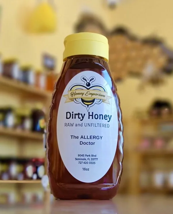 A bottle of Dirty Honey on a shelf with the other bottles of honey in the background out of focus.