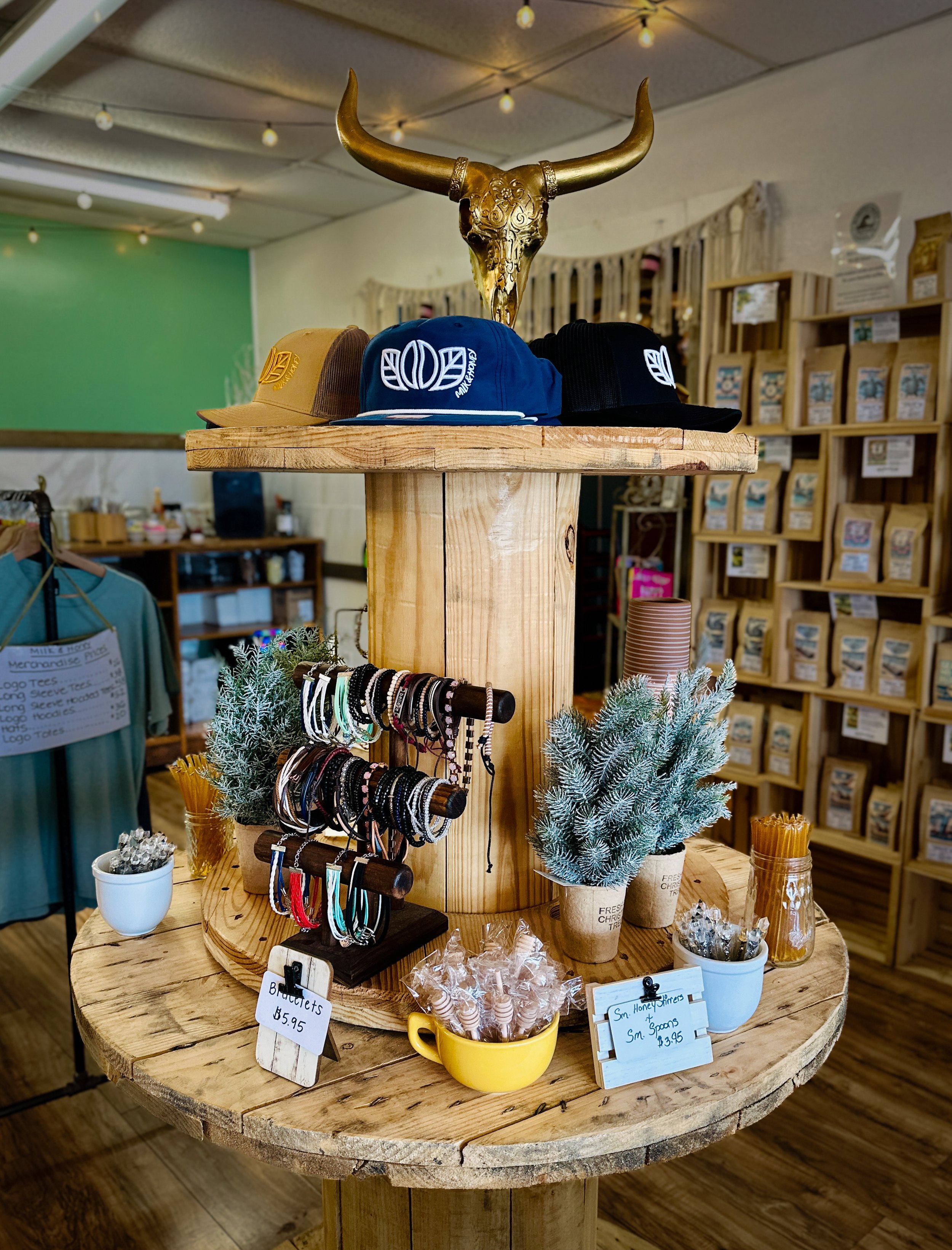 Candles, jewelry, hats and candy on a wooden wheel dispay.