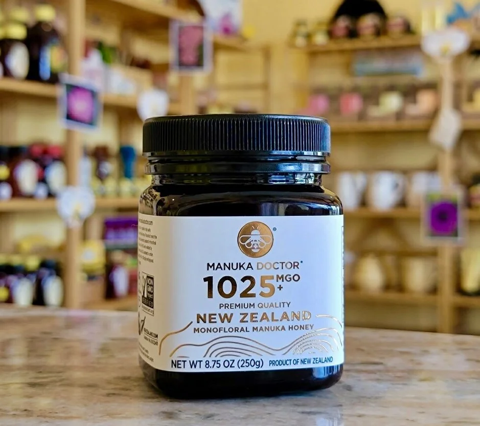 Bottle of Monofloral Manuka Honey from New Zealand on a marble table with the store shelves in the background out of focus.