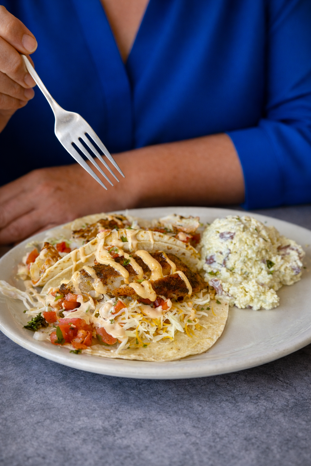 Tacos with potato salad on a marble table.