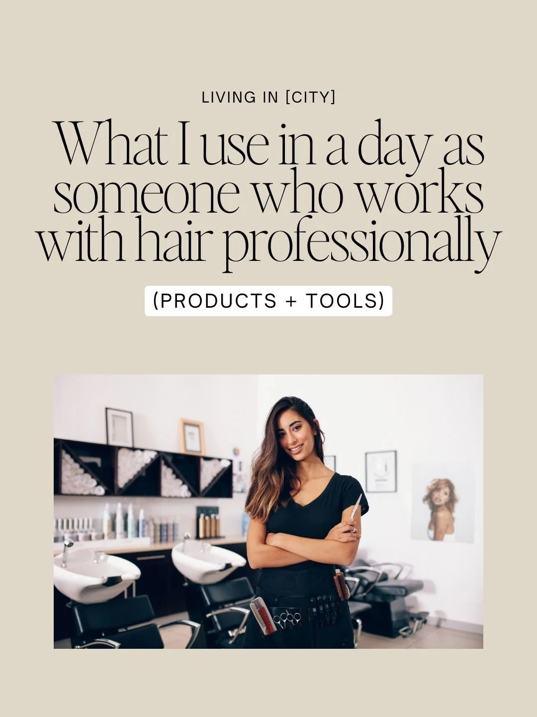 A woman in a black salon apron holding a hairbrush in a hair salon with washing sinks, hair products, and framed pictures in the background.