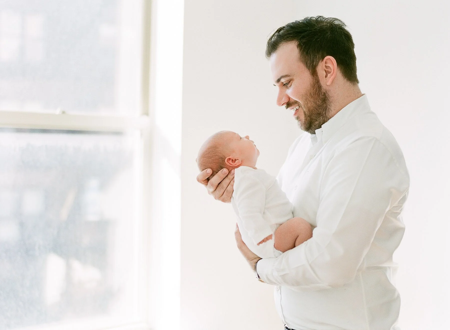 Dad and baby in window light