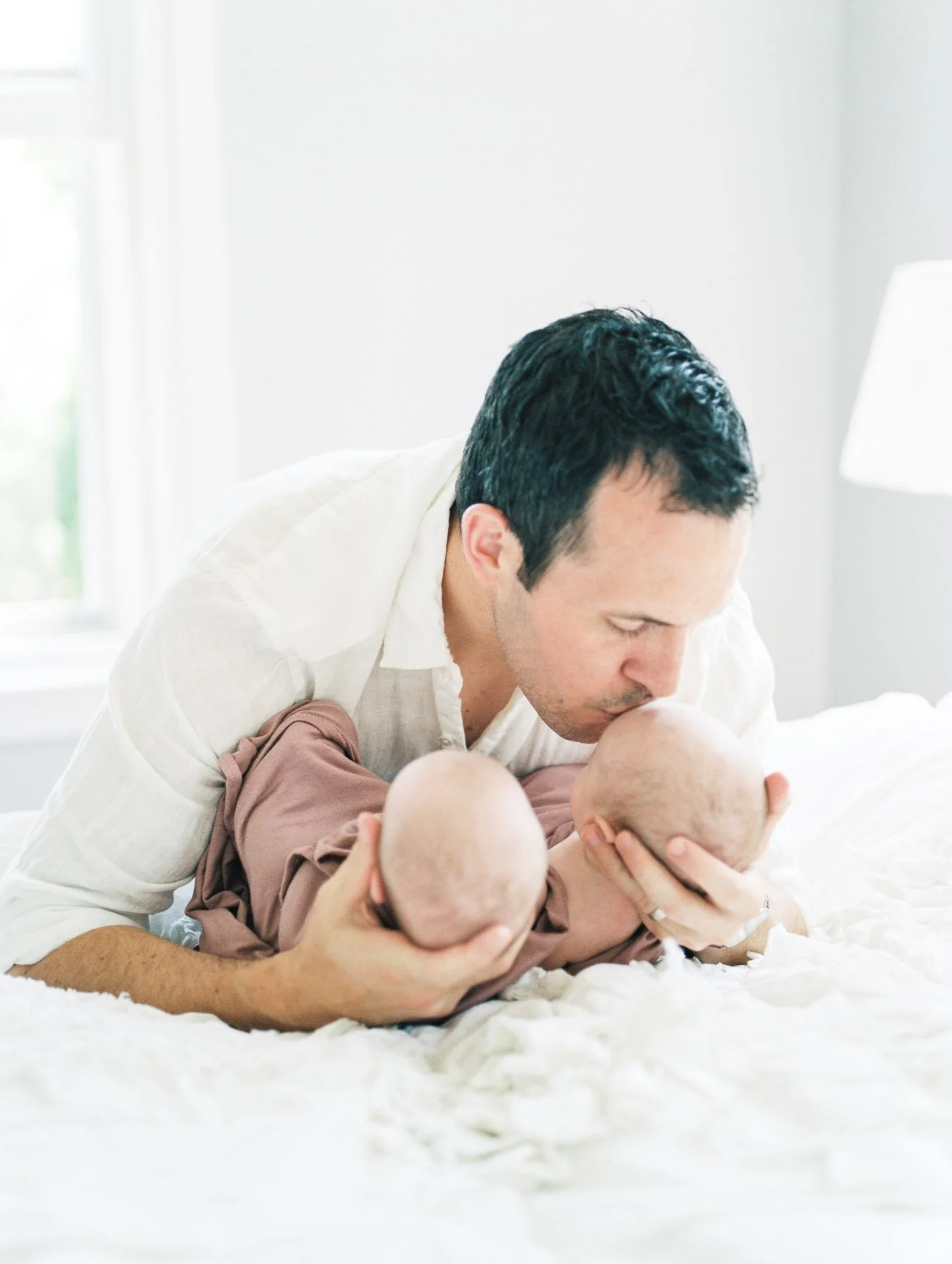 Father Kissing Twin Babies 