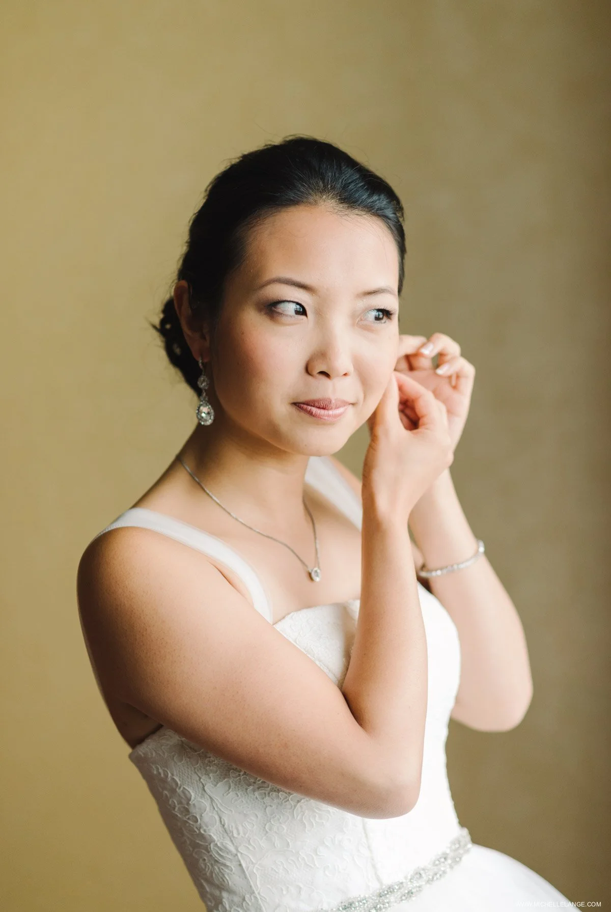 Bride Putting on Earrings