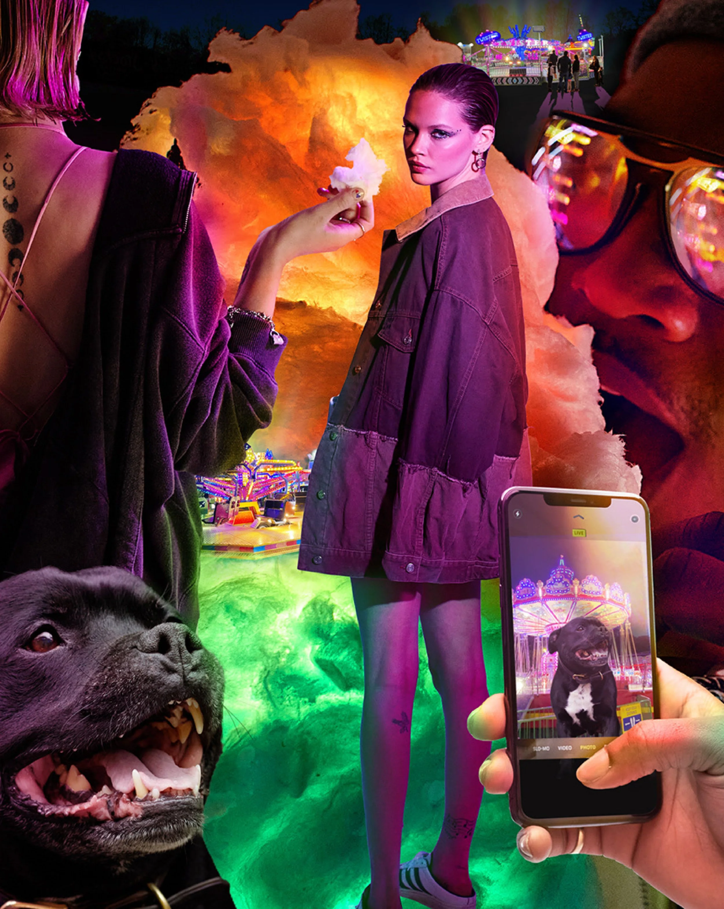 A nighttime scene at an amusement park with colorful lights. In the foreground, a black dog with an open mouth showing its teeth is being used as a prop. To the right, a person is taking a photo of a woman with purple hair and makeup, wearing a purpl