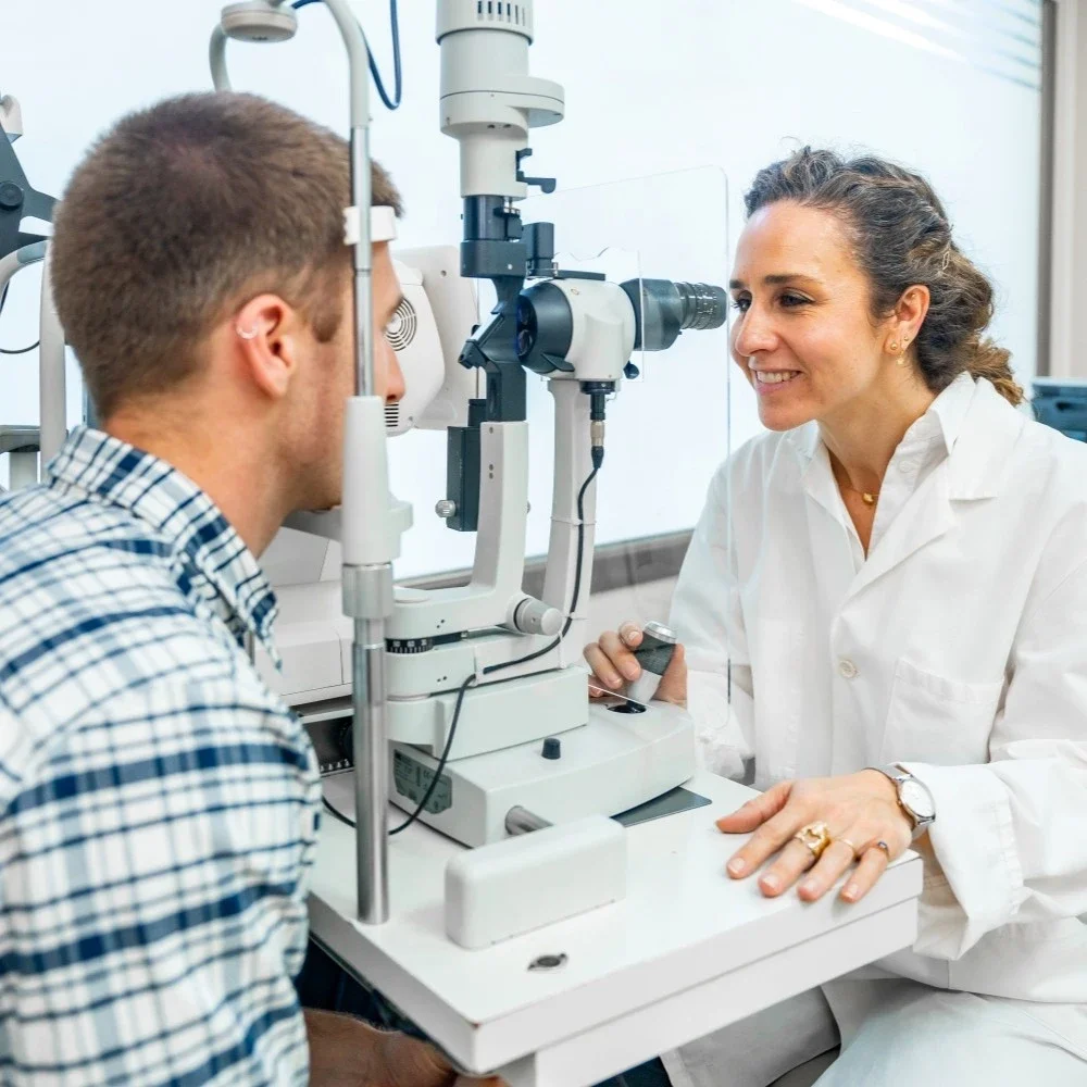 Optometrist performing eye exam on a patient using slit lamp in clinic