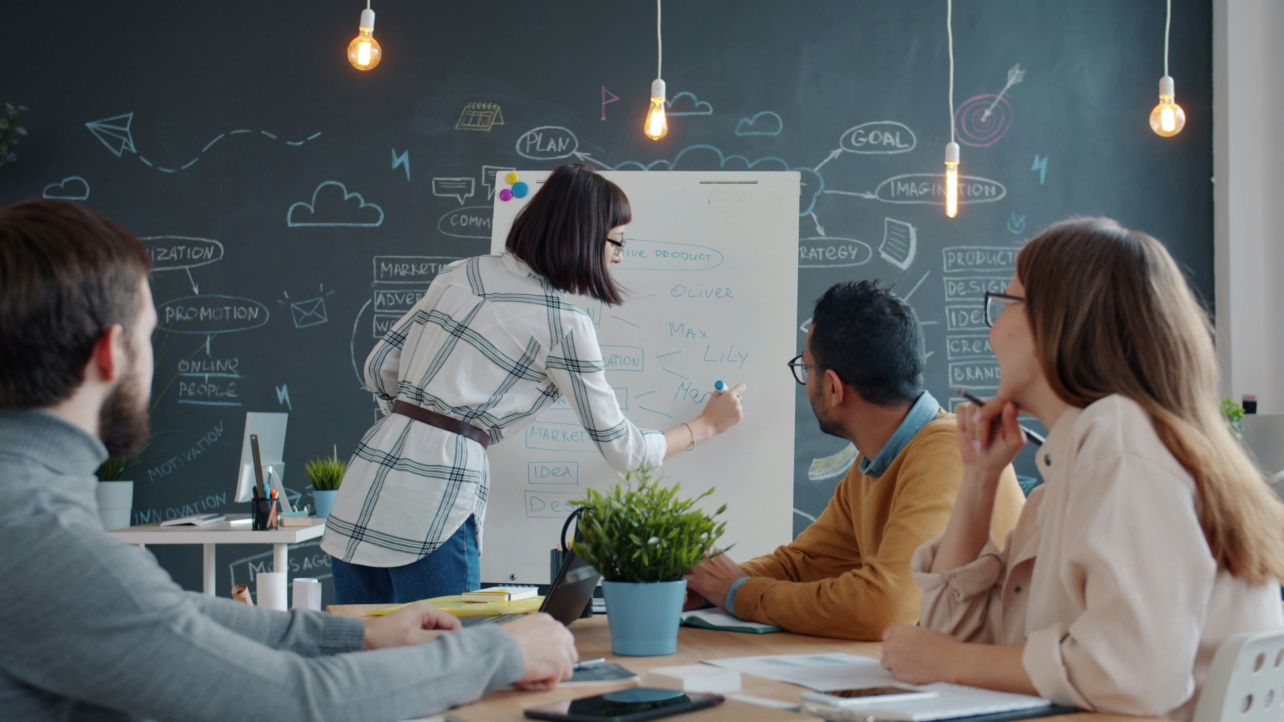 A team discussing ideas around a whiteboard during a planning workshop.