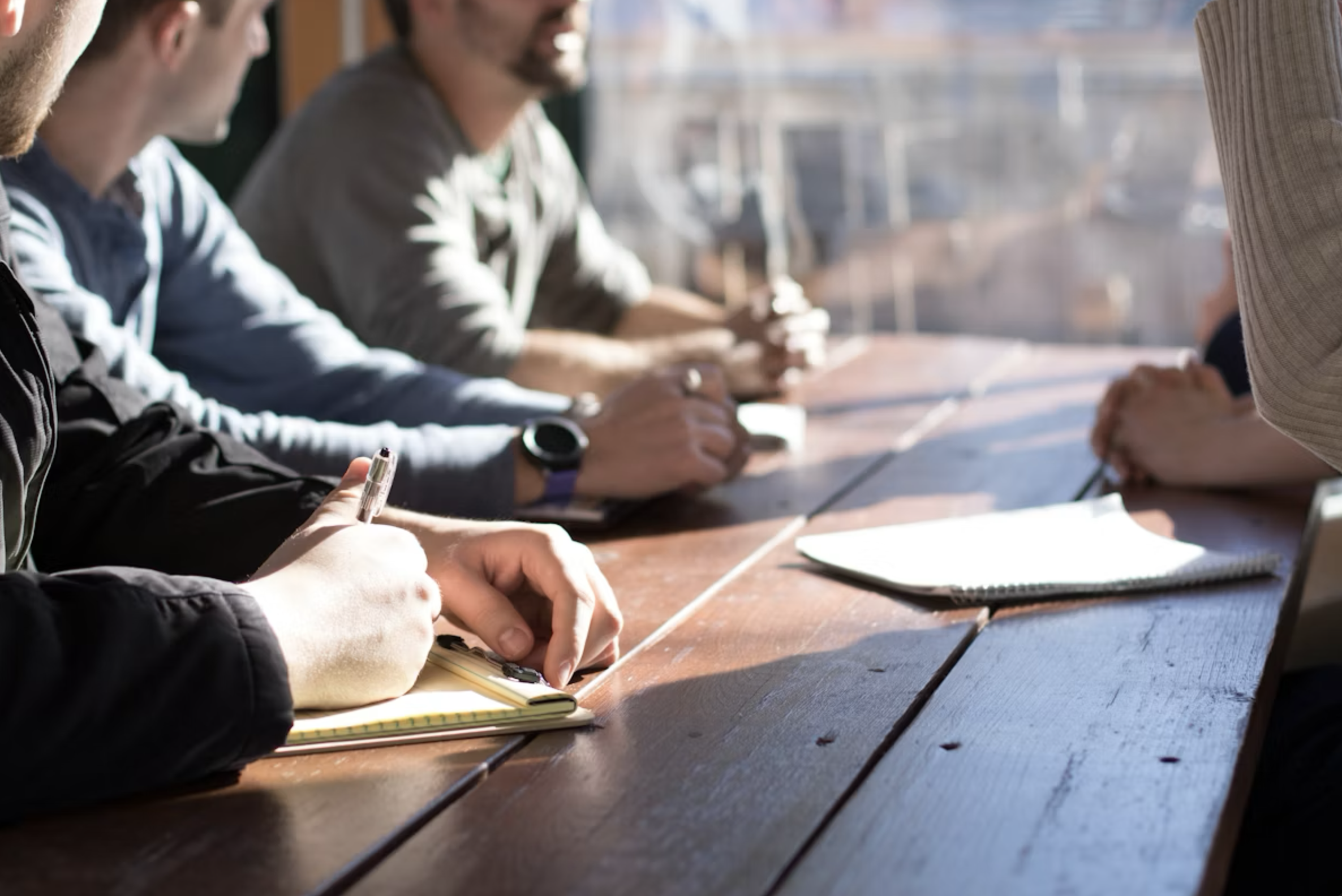 Colleagues discussing work around a table during a meeting.