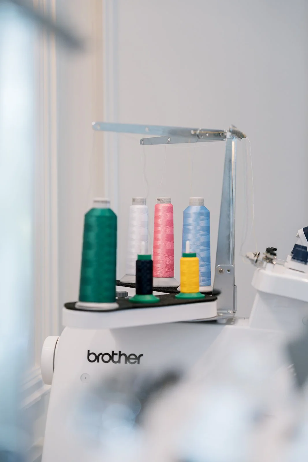 Sewing machine with colorful spools of thread on top.