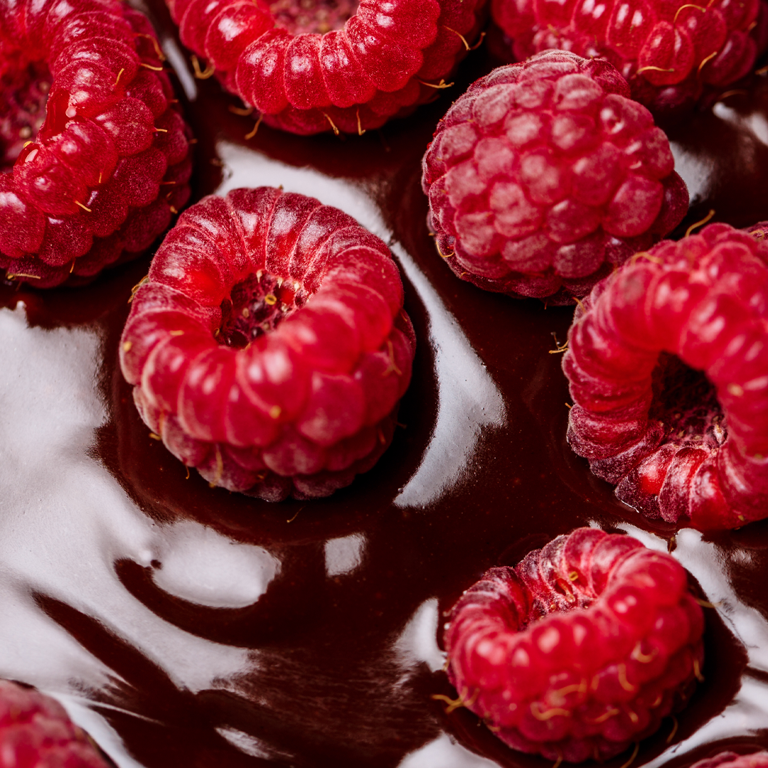 Close-up of fresh raspberries on a chocolate dessert.