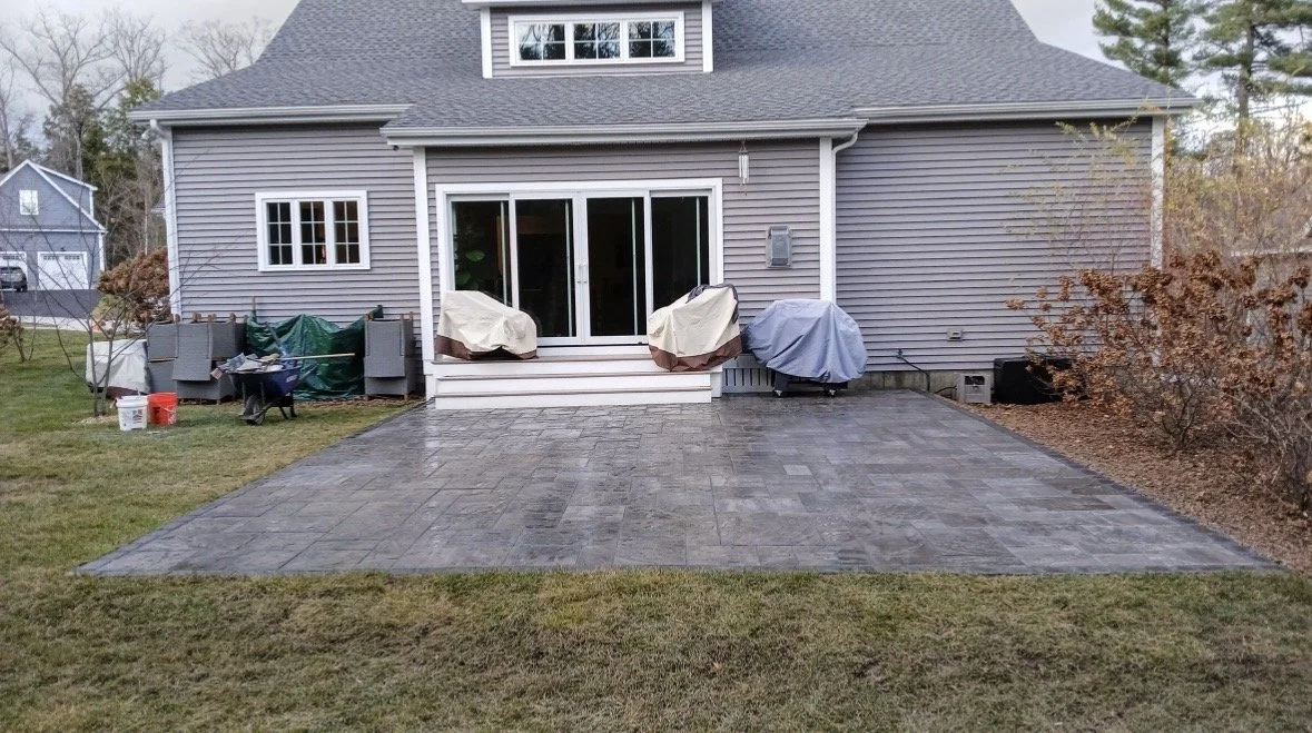 Backyard patio landscaping with gray brick pavers in Concord, New Hampshire