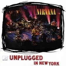 Album cover of Nirvana's 'Unplugged in New York' featuring a live performance scene with band members on stage and the album title at the bottom.