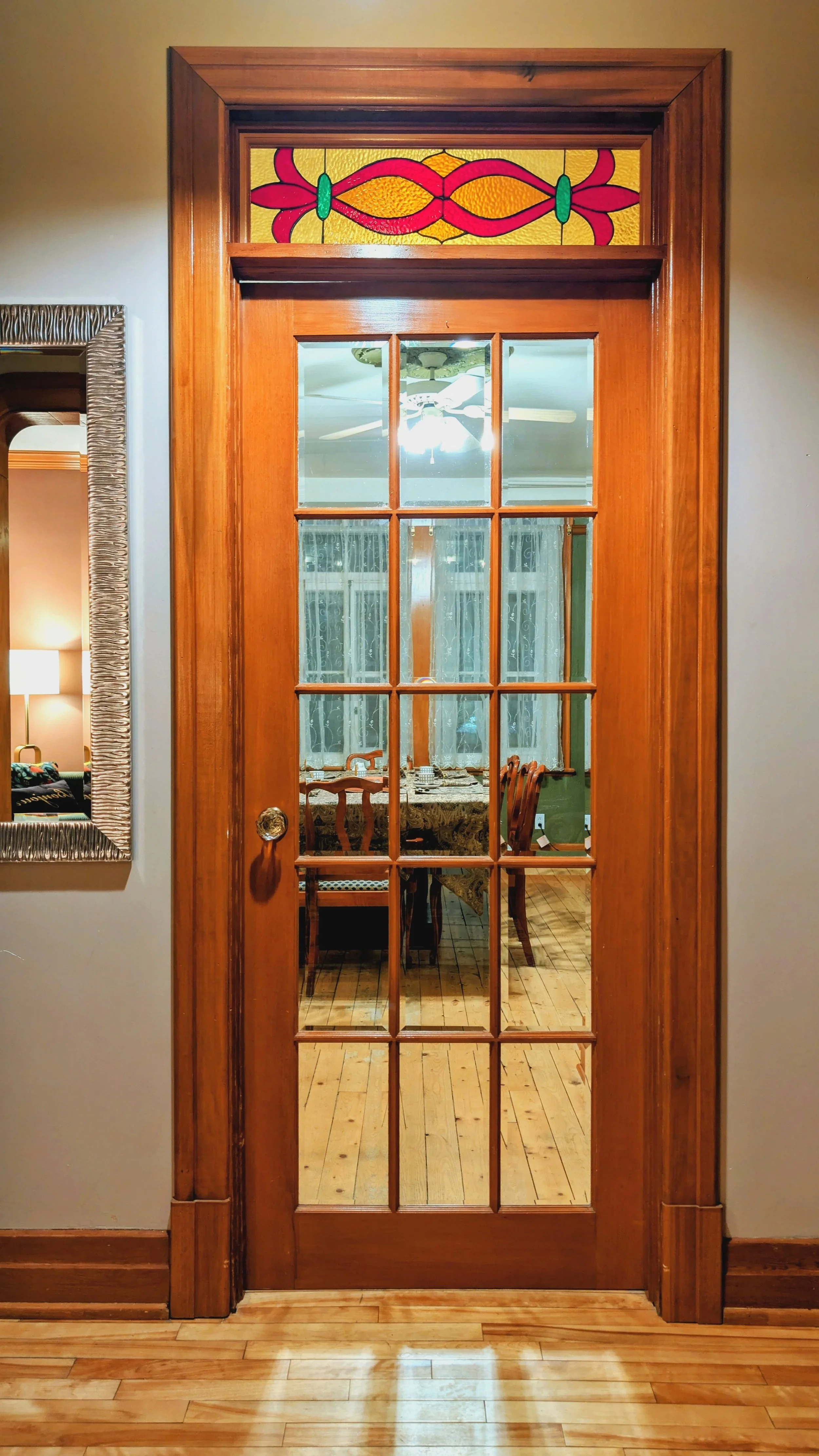 Vue de la porte donnant sur la salle à dîner, avec son imposte en vitrail