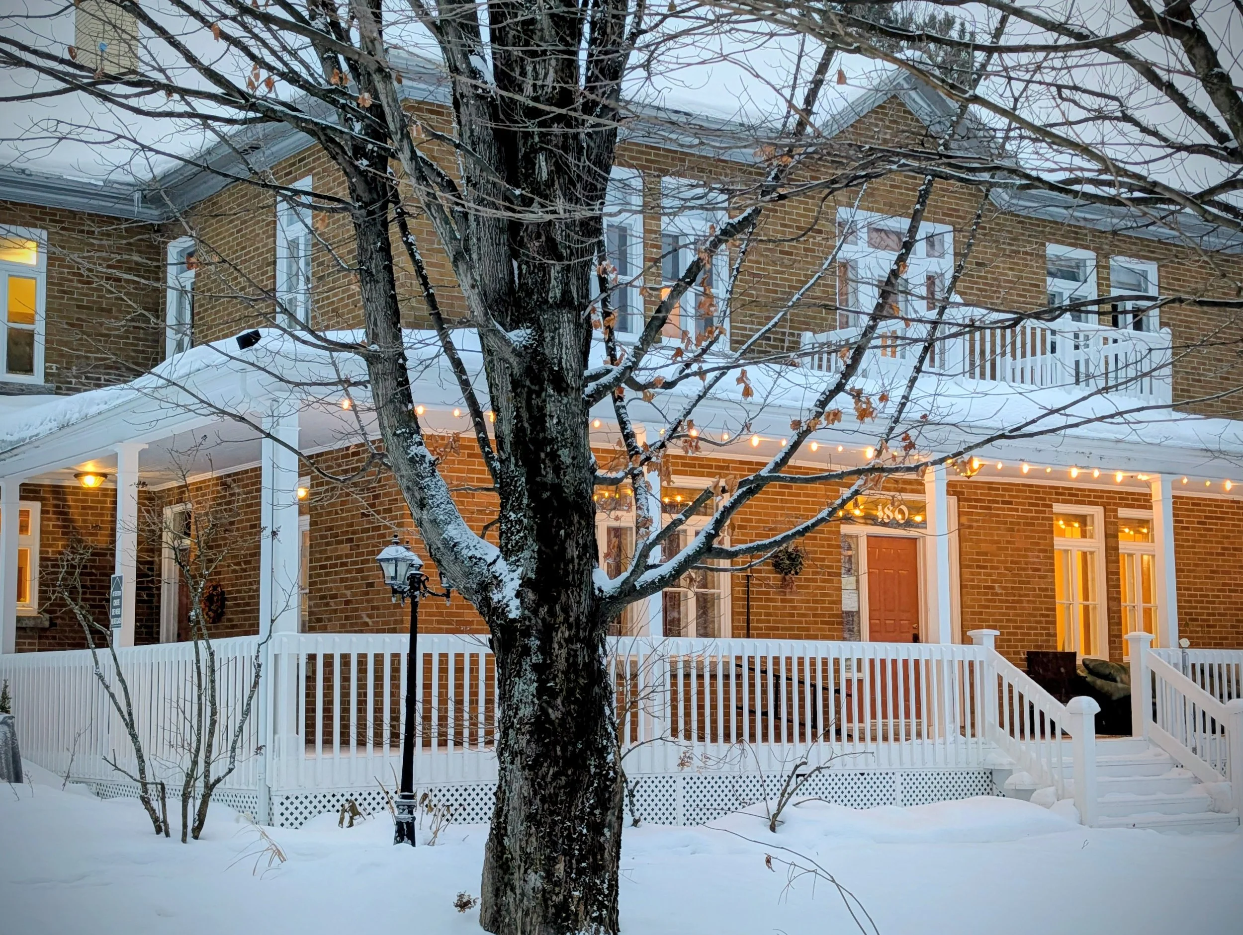 Vue extérieure de la Maison La Miellée, avec la guirlande de lumières éclairant la galerie couverte