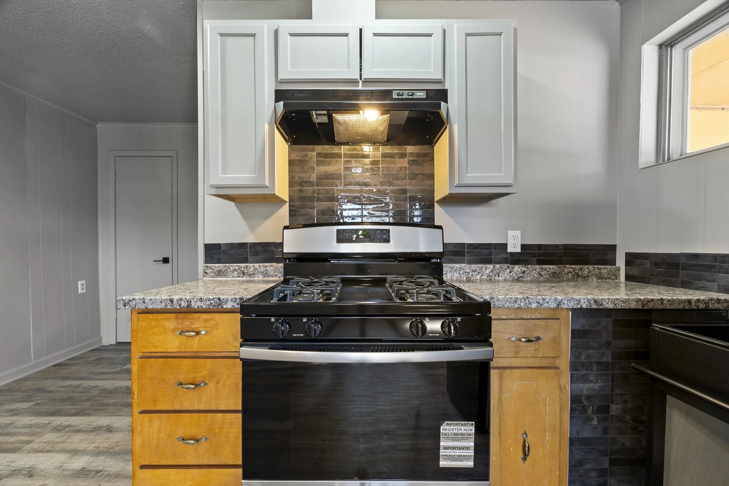 Kitchen with new stove and refrigerator, vinyl plank flooring