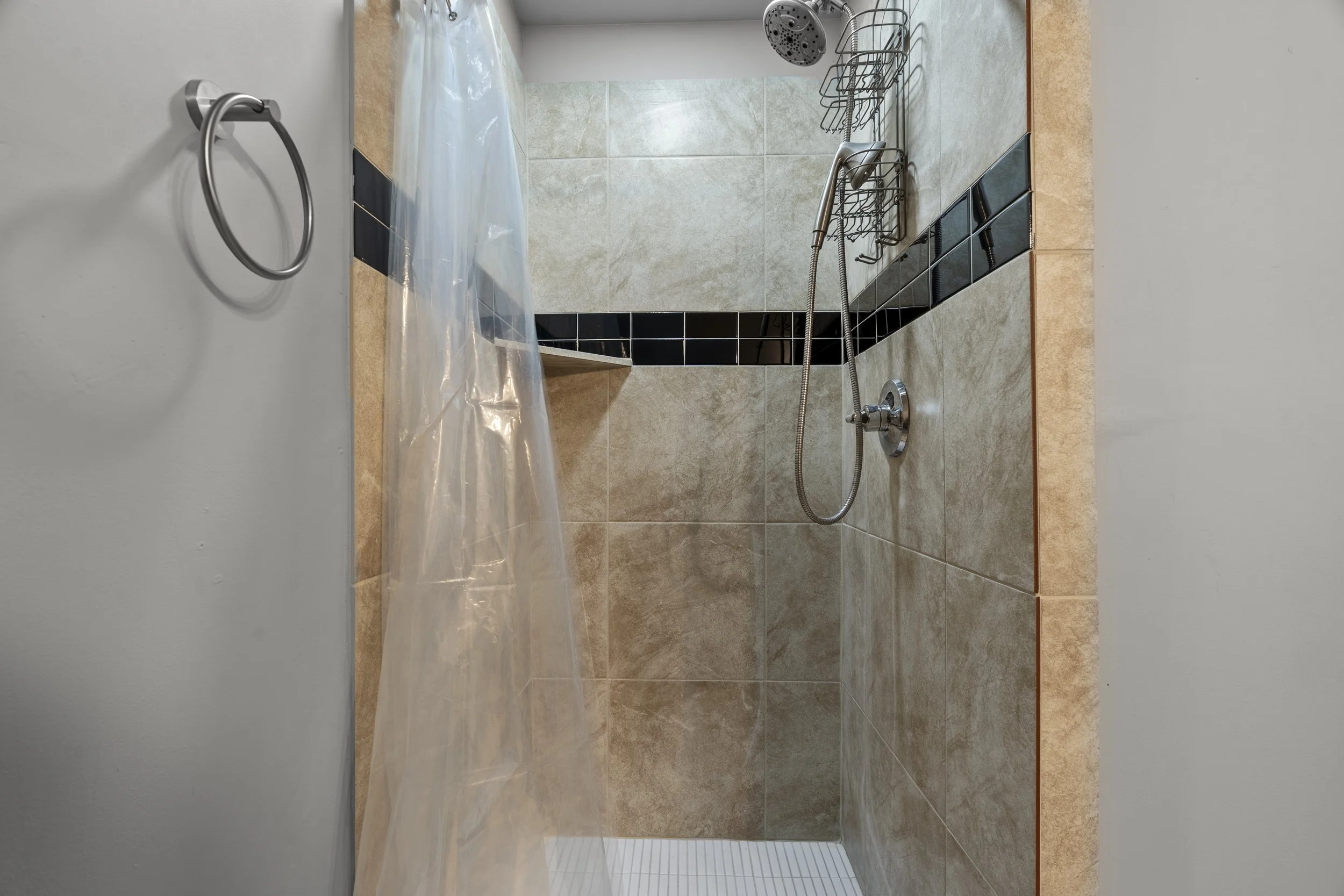 Beautifully tiled shower, with chrome accessories. 
