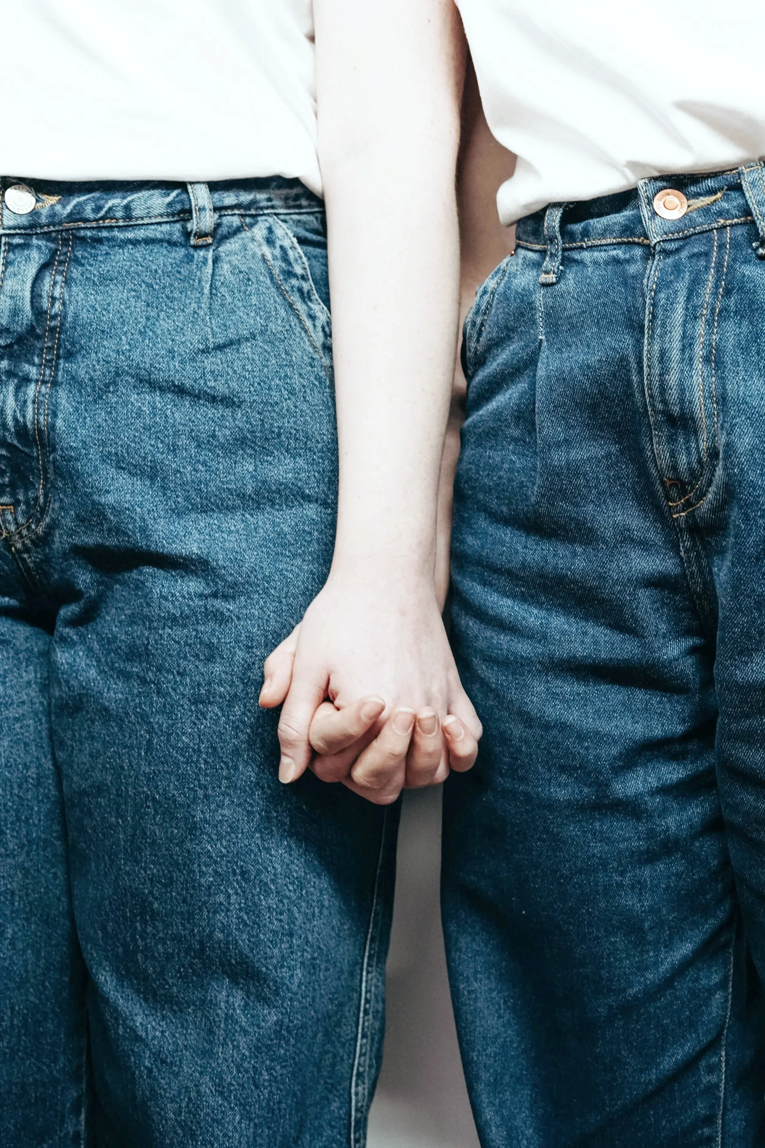 Two people, holding hands and standing close together.