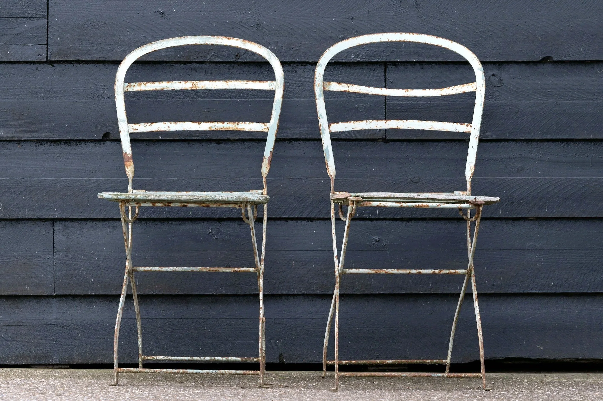 Two empty metal chairs, side by side.
